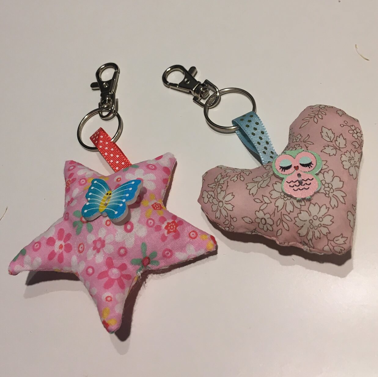 Porte-clés en tissu liberty et rubans ornés de boutons décoratifs réalisés pour la fête des mère par deux élèves débutantes en couture lors d'un atelier à thème